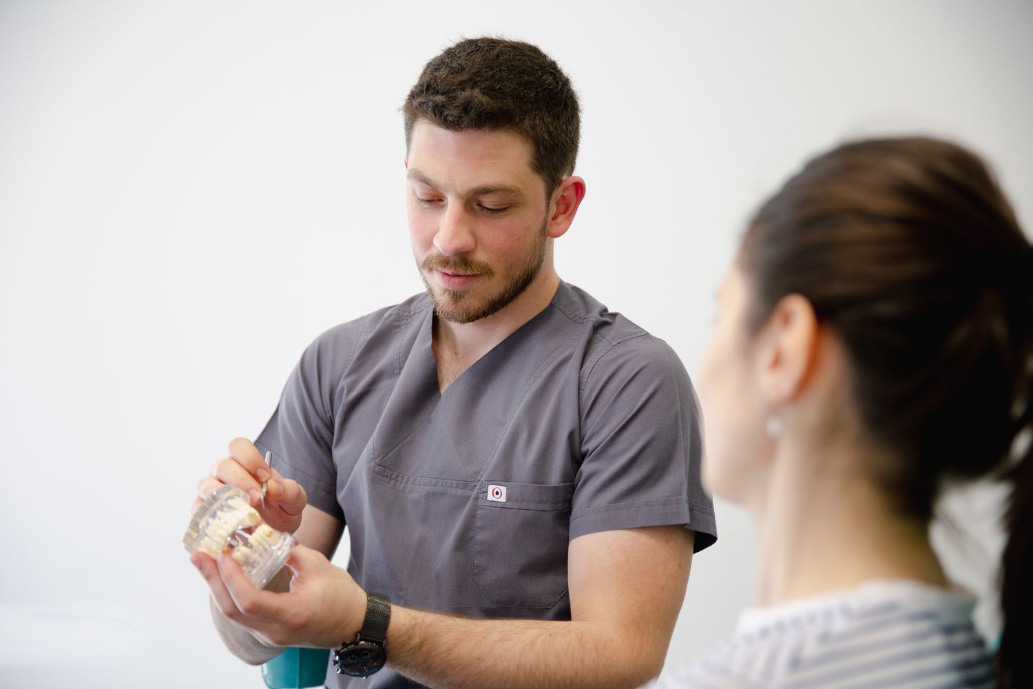 A dentist explaining treatment using a model